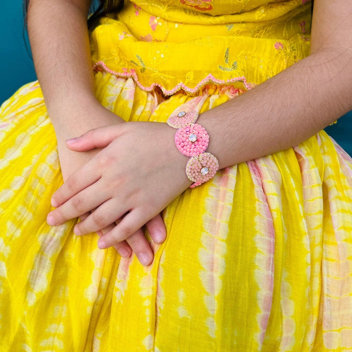 "Peach pink orange hand bracelet with stone at center, artisan-made for girls 0–1 year to teens 13–14 years, soft irritation-free with secure closure – styled in Gurgaon posh ethnic wear venue."